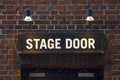 Stage Door sign on a wall outside a theatre.