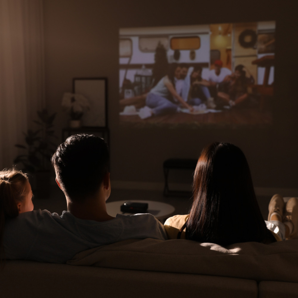 Family,Watching,Movie,On,Sofa,At,Night,,Back,View