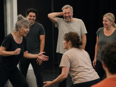 Adults taking part in an energetic drama and acting exercise during a performing arts class