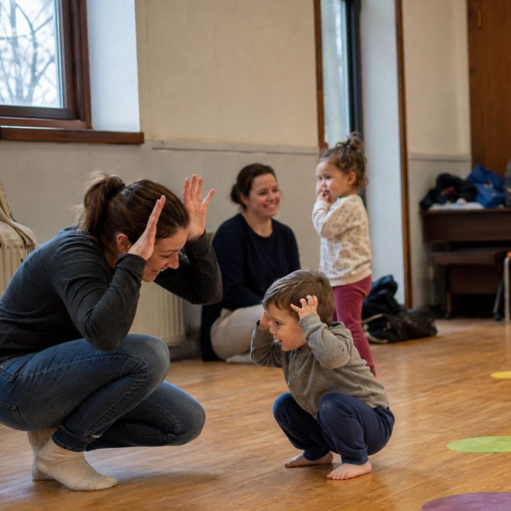 Parents and toddlers taking part in a playful movement activity together in a community hall class